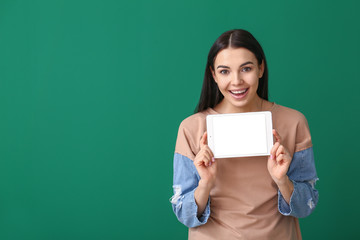 Poster - Beautiful young woman with tablet computer on color background