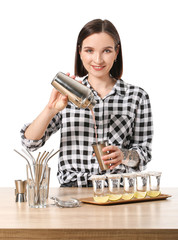 Wall Mural - Beautiful female bartender at table against white background