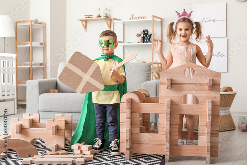 Fotografía Little children in costumes playing with take-apart house at home