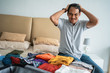© Odua Images - stressed young man after receiving a flight ticket cancellation when preparing her clothes in the suitcase before go to long trip