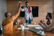 © JonoErasmus - Two African businessmen giving high five while diverse South African coworkers clapping in congratulations