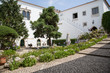 Dorf Óbidos, Portugal: Garten Innenhof mit Naturstein Treppen umrahmt von Reihen mit lila und weissen Schmucklilien