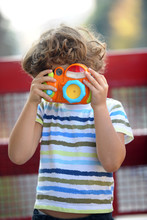 Child Learns To Take Pictures In A Park With A Professional Reflex Camera