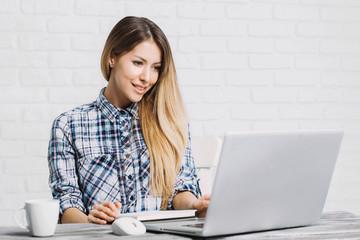 Student girl using laptop computer studying at home. Young woman working in her room. Online shopping, work or study from home, freelance, online learning, distance education concept