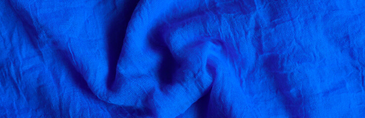 background of bright dark blue cotton wrinkled fabric cloth. banner. toned in classic blue color trend 2020 year
