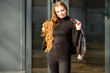 © Вячеслав Чичаев - Portrait of a pretty beautiful young girl with long hair with a smile in the park against the background of a wall of a business building. Photo taken in sunny weather outdoors in spring.