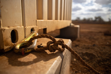 Wall Mural - Safety workplace crane safety tag line  attached into 2.5 ton pig ears lifting lug which it clpping on corner of while containers prior lifted 