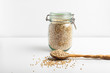 A spoonful of green dry buckwheat and a glass jar, copy space