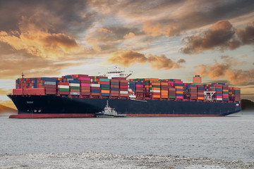 Logistics and container loading by large barges by sea in a harbor full of containers waiting to be transported