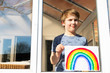 Boy holding up an image of a rainbow