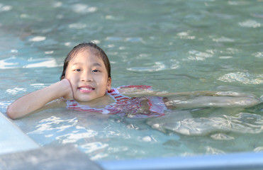 Smiling cute little girl in swimming pool