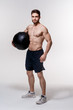 © Ilnur - a male athlete in good physical shape on a white background with a medball in his hands