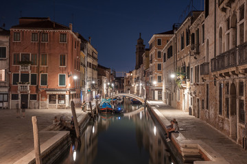 Wall Mural - Narrow canal with boats and vintage houses at dusk. Venice city at night