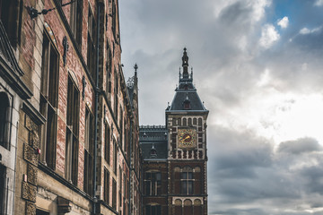 Wall Mural - Amsterdam central station, tourist square with a marked sky