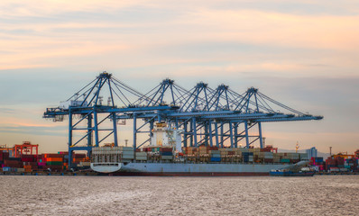 Logistics and transportation of container ships, container and cargo vessels that operate at the shipyard at sunrise. Export and import of the logistics.