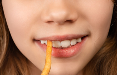 mouth teenage girl eating French fries closeup.