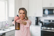 © labelled4 - Young woman spraying natural disinfectent at the camera in the kitchen