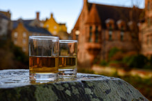 Scotch Single Malts Or Blended Whisky Spirits In Glasses With Old Houses Of Edinburgh On Background, Scotland, UK