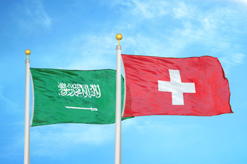 Saudi Arabia and Switzerland two flags on flagpoles and blue cloudy sky