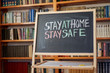 © Andrii - inscription stay at home. Outbreak Warning. written white chalk on blackboard in connection with epidemic of coronavirus worldwide.