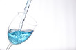blue liquid pouring into a wine glass