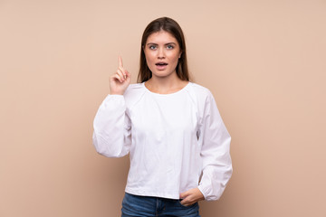 Young girl over isolated background thinking an idea pointing the finger up