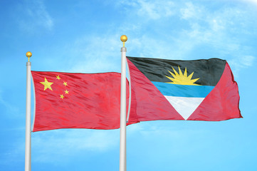 China and Antigua and Barbuda two flags on flagpoles and blue cloudy sky