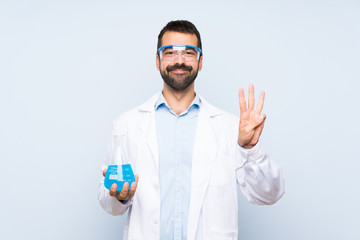 Wall Mural - Young scientific holding laboratory flask over isolated background happy and counting three with fingers