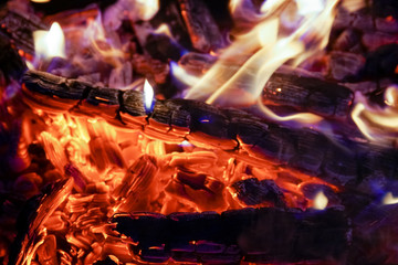 Burning firewood in the fireplace close up, BBQ fire, charcoal background. Charcoal fire with sparks