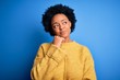© Krakenimages.com - Young beautiful African American afro woman with curly hair wearing yellow casual sweater with hand on chin thinking about question, pensive expression. Smiling and thoughtful face. Doubt concept.