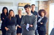 © Krakenimages.com - Group of business workers smiling happy and confident. Posing together with smile on face looking at the camera, young handsome man with crossed arms at the office