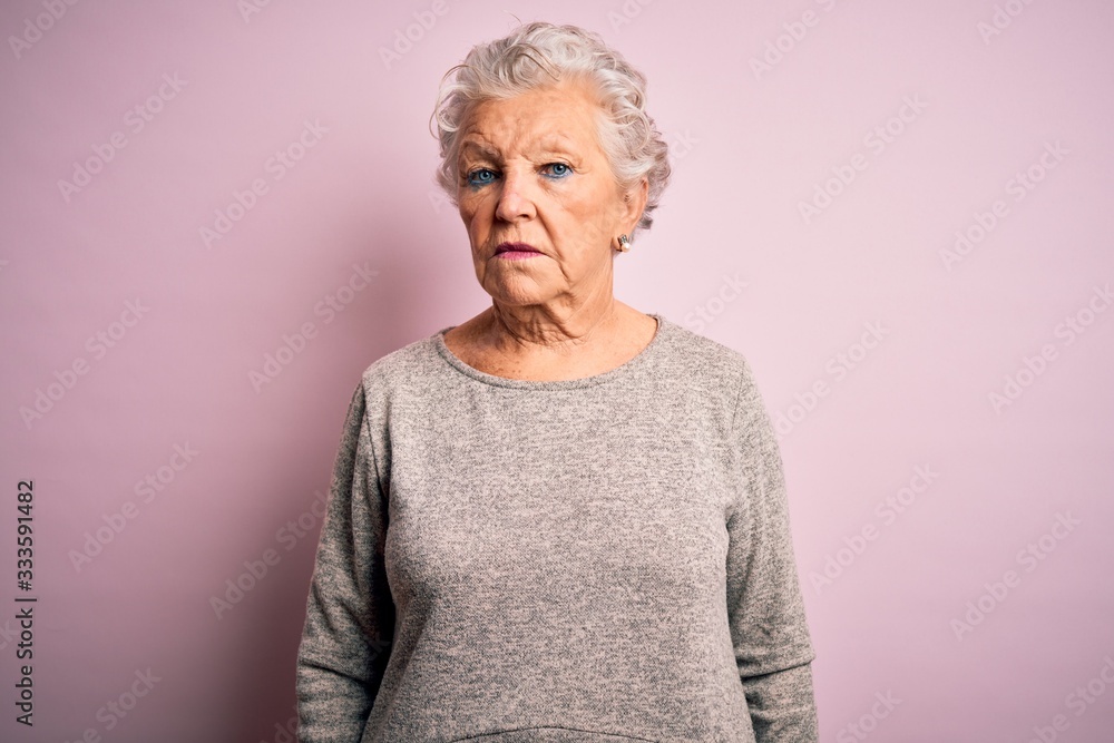 Senior beautiful woman wearing casual t-shirt standing over isolated pink background looking sleepy and tired, exhausted for fatigue and hangover, lazy eyes in the morning. - obrazy, fototapety, plakaty 