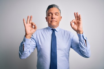 Poster - Middle age handsome grey-haired business man wearing elegant shirt and tie relaxed and smiling with eyes closed doing meditation gesture with fingers. Yoga concept.