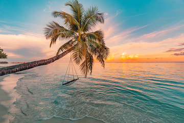 Wood swing beautiful sunset on the sea beach. Amazing tranquility 