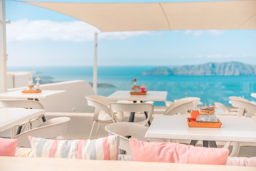 Wall Mural - Greece, Santorini. Restaurant with served table in seafront of Aegean sea on Santorini Cyclades island with breathtaking, amazing and picturesque view in outdoor restaurant Oia. Summer vacation travel