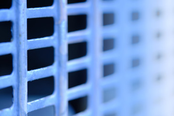 Abstract macro photography. Close up blue fence with square grid pattern