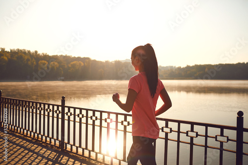 Fotomural Back view of a runner walking on a road in a park