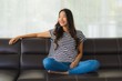 © siraphol - Portrait beautiful young asian woman happy smile relax on sofa in living room