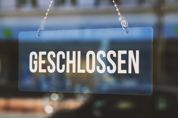 sign geschlossen - closed in german - economy crisis or business closure concept