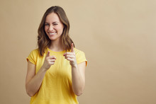 Happy Young Woman Pointing At The Viewer. Nice Color Portrait