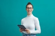 © Martin Villadsen - Smart looking girl with glasses looks into the camera with a big smile, holding a tablet