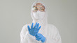 © RedcupStudio - Asian doctor in protective hazmat PPE suit wearing medical latex gloves