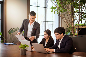 Co-working space concept. Businessman and Businesswoman is brainstroming in a co working space. Company employees are sitting in front of laptop computers.