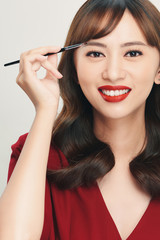 Wall Mural - Asian young beautiful woman applying cosmetic powder brush on eyebrow, natural makeup, beauty face