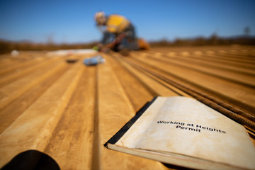 Wall Mural - work safe practices working at heights permit book with defocused trained construction rope access m
