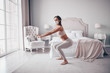 © Алина Троева - Home fitness. Young fit slim woman in protection face mask doing morning work-out yoga exercises in bedroom during self isolation quarantine. COVID-19 concept to promote stay safe home save lives