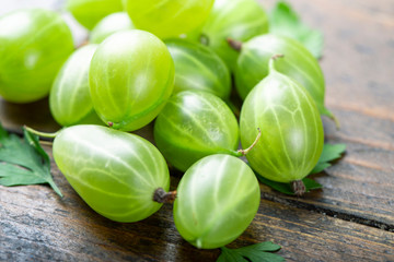 Wall Mural - Sweet fresh gooseberry berry on wood background.