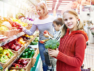 Girl and broccoli in supermarket