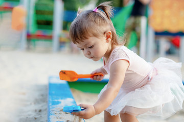 little girl is playing on the playground happy child is relaxing with mom rejoices and laughs