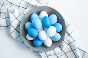 Wall Mural - chicken eggs white and brown color in a gray plate on a checked kitchen towel on a white table. concept farm products and natural nutrition. toned classic blue color trend 2020 year